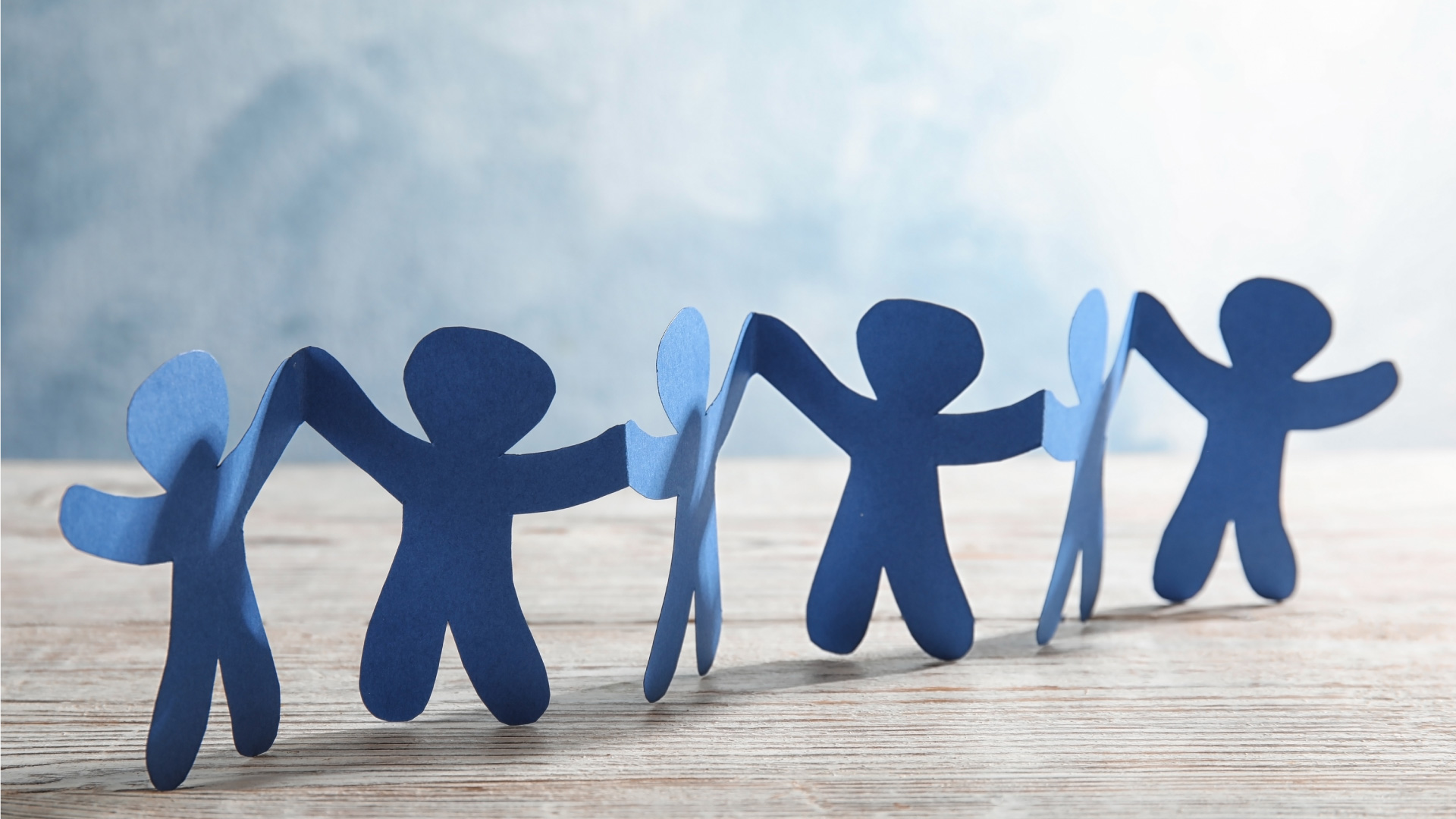personaggi in carta che si tengono per mano a simboleggiare il volontariato e il lavoro di rete